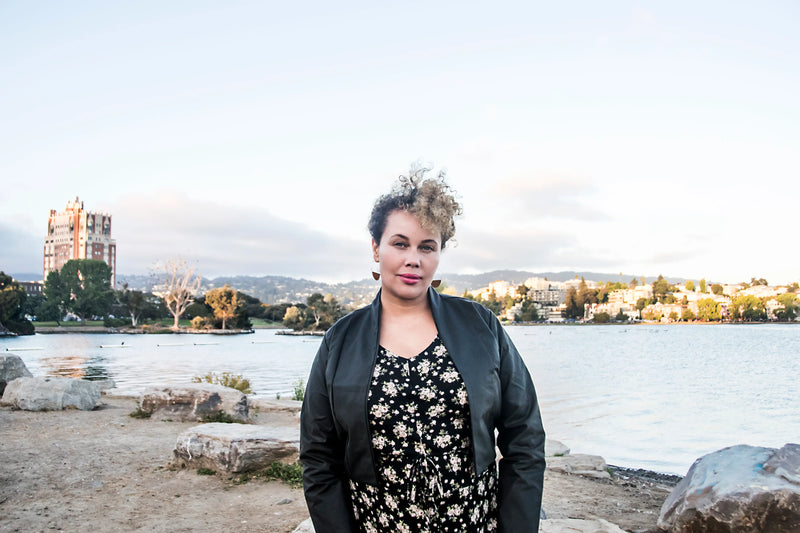 woman at lake merritt looking a camera wearing a filed day jacket