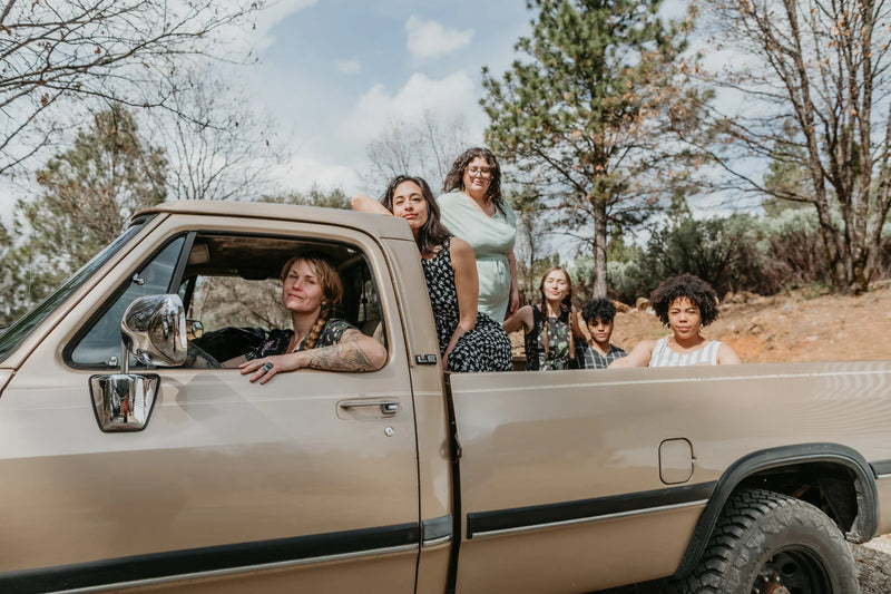 women in dresses in a dodge truck